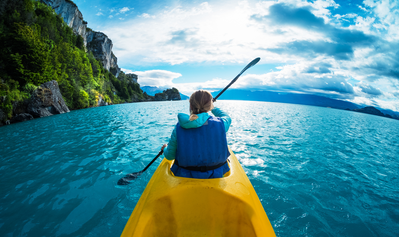 una mujer haciendo kayak frente a un hermoso paisaje